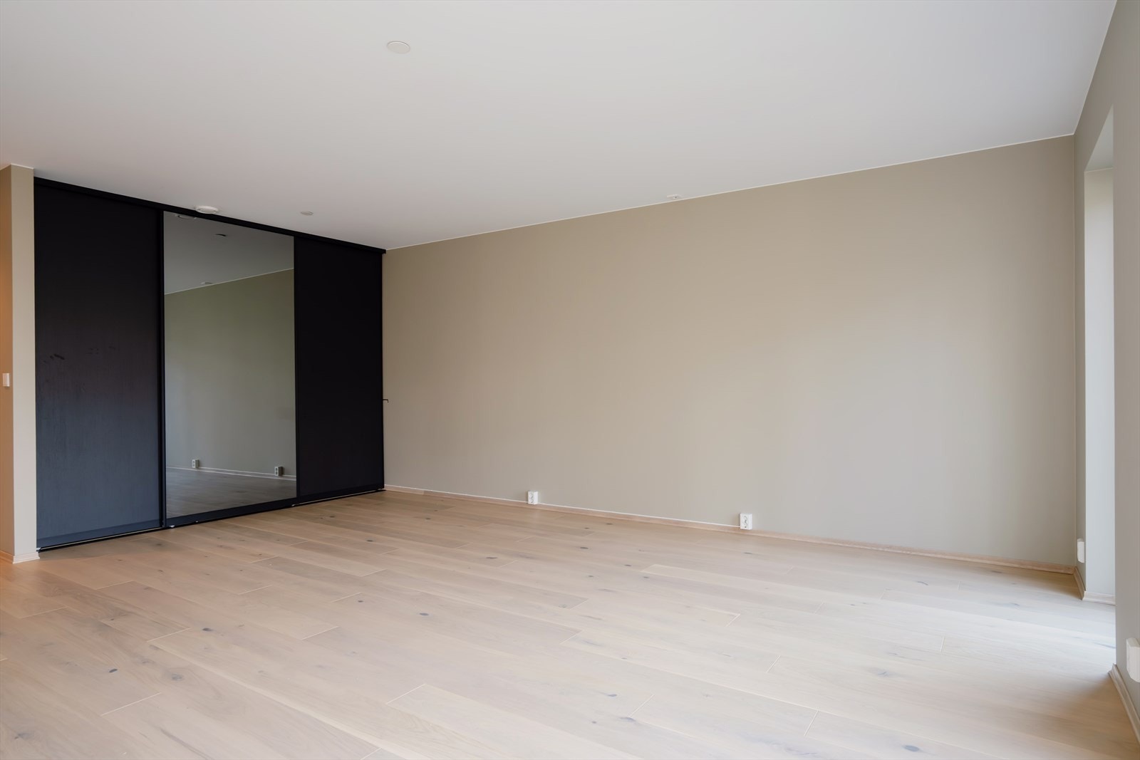 Stue i egen avskjermet del. Skyvedørsgarderobe gir effektiv oppbevaring og utnyttelse av veggplass. Galleribilde