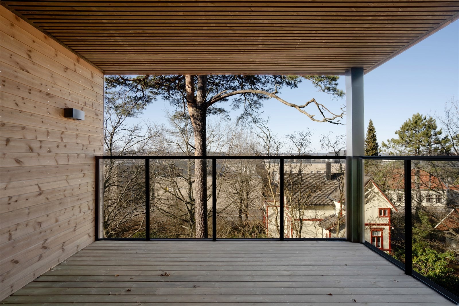 Overbygget terrasse med trepanel gir en skjermet uteplass. Galleribilde