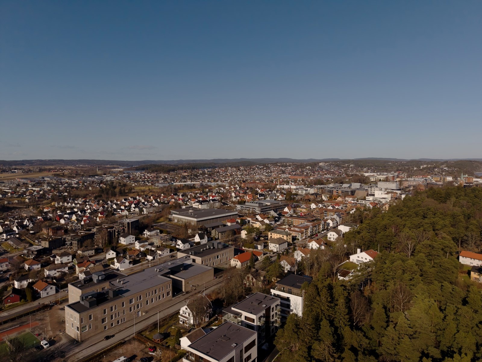 Oversiktsbildet viser at beliggenheten gir en kombinasjon av urbane og grønne omgivelser. Galleribilde