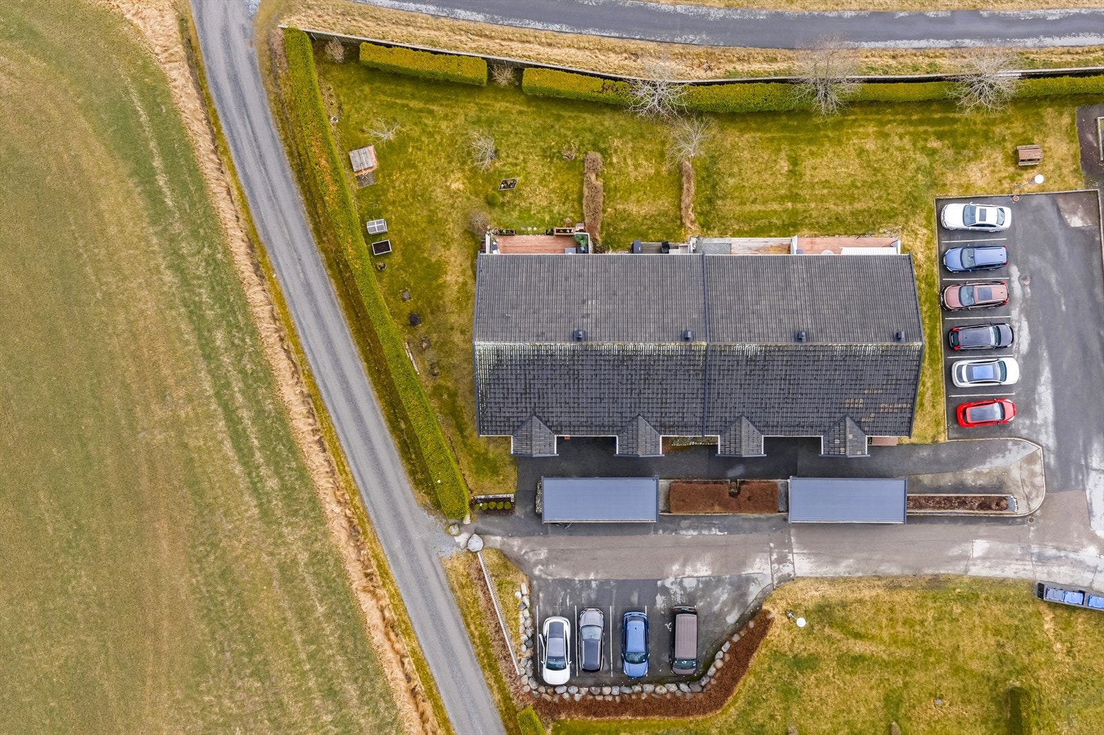 Oversiktsbilde som viser eiendommens plassering i rekken, med hage og parkeringsareal. Galleribilde