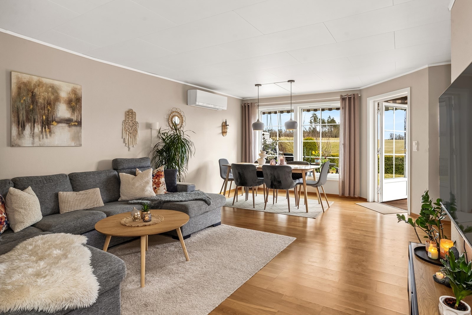 Fra sofakroken har man utsyn mot hagen og direkte tilgang til uteplassen. Galleribilde