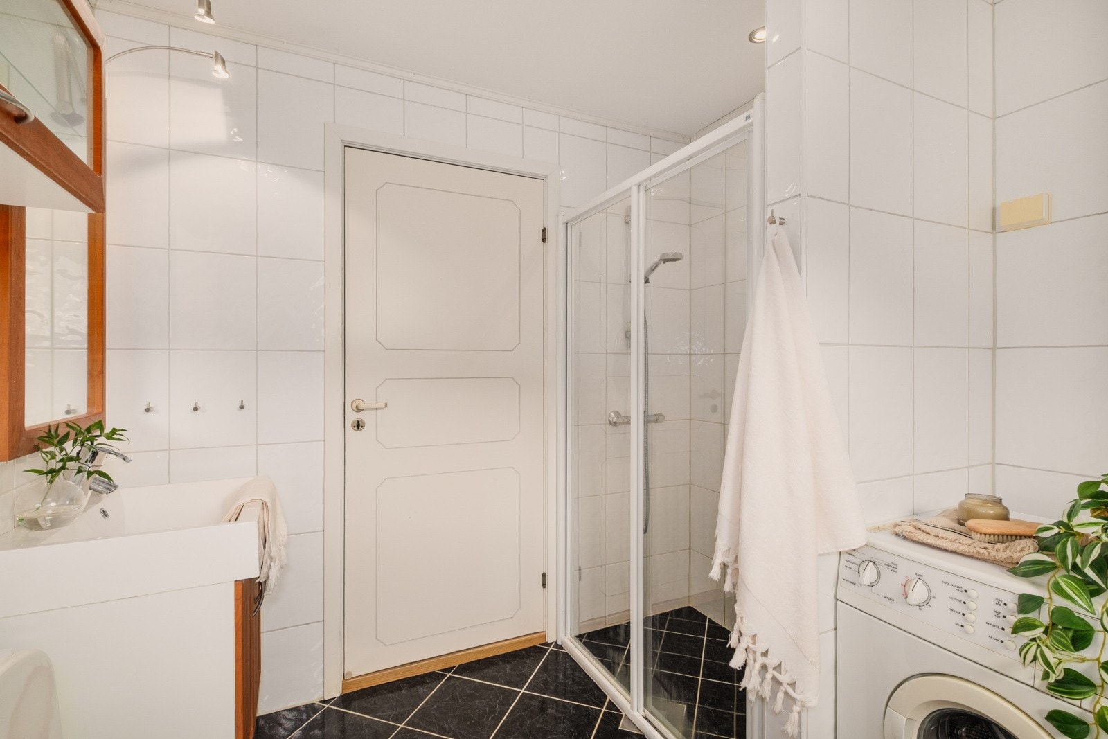 Her er det dusjhjørne med glassvegger og praktisk opplegg for vaskemaskin. Galleribilde
