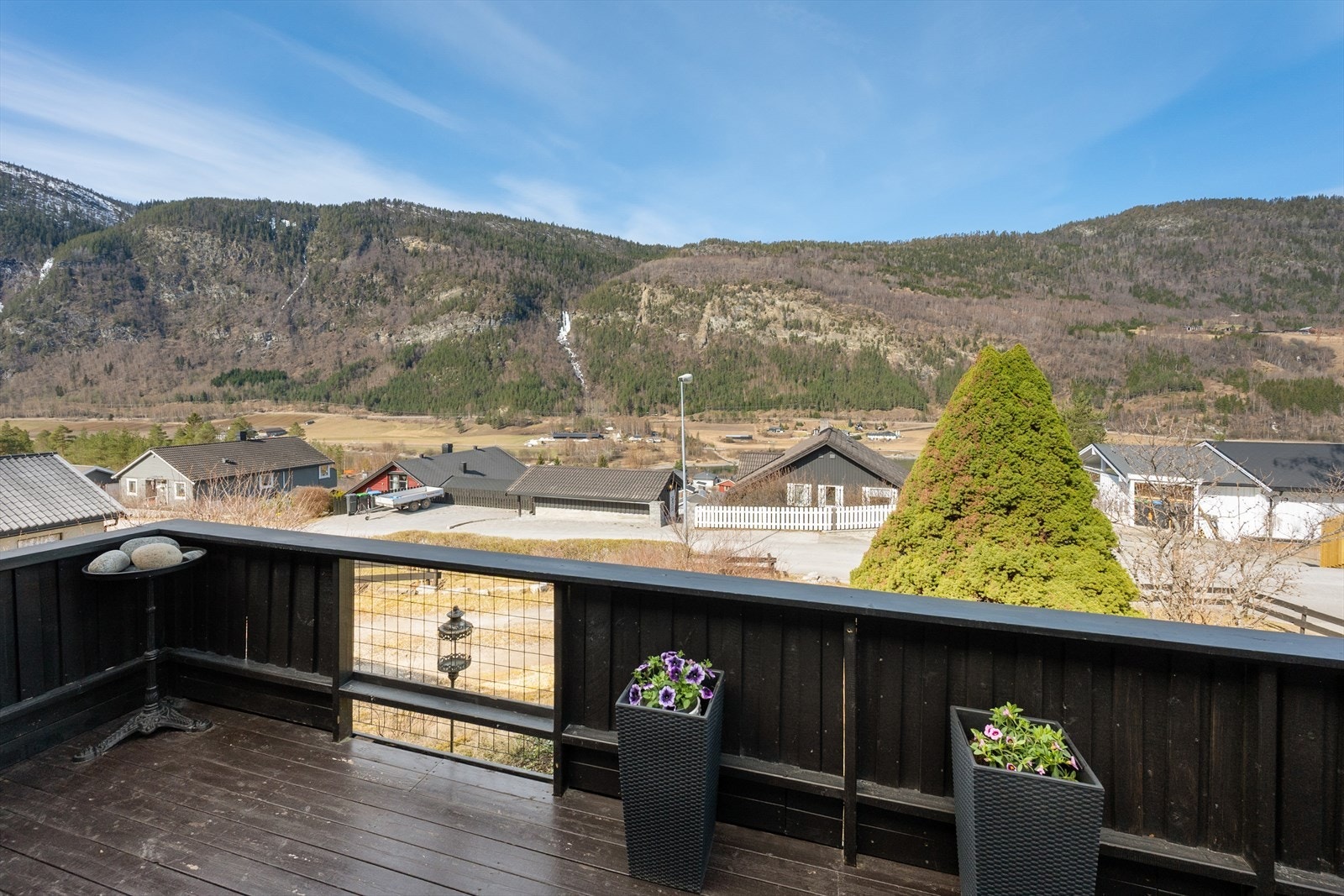 Fra terrassen utenfor stua er det utsikt over nærområdet og de omkringliggende åssidene. Galleribilde
