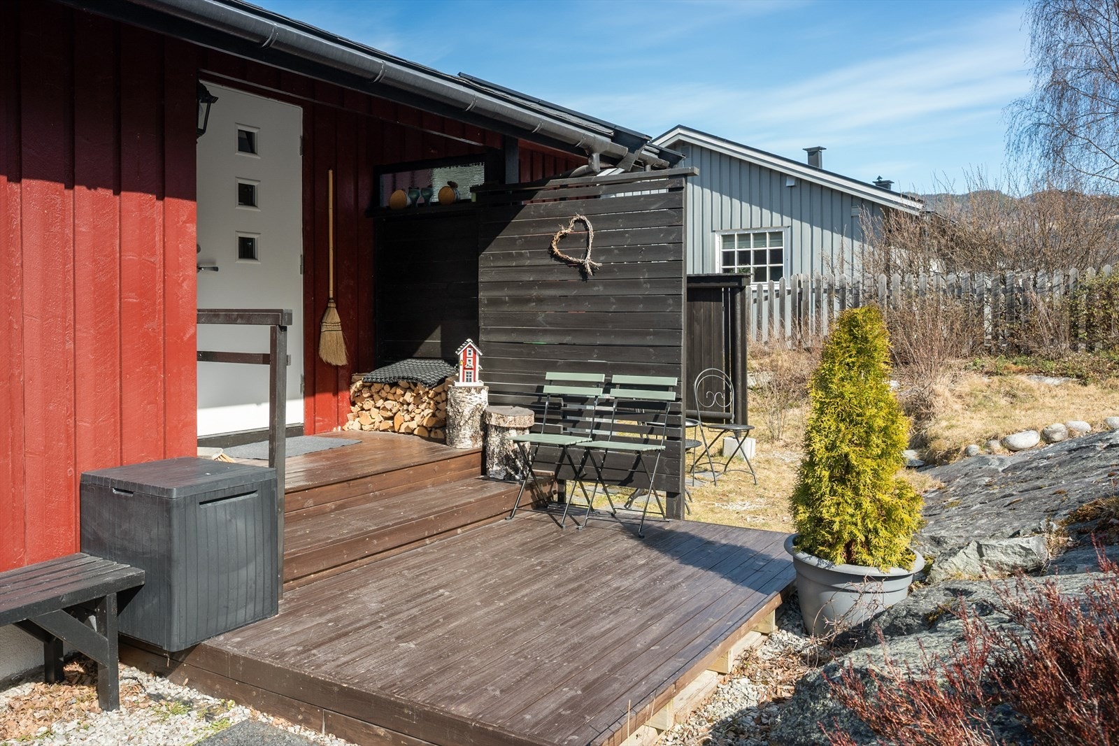 Et overbygd inngangsparti med terrasseplatting skaper en hyggelig velkomst. Galleribilde
