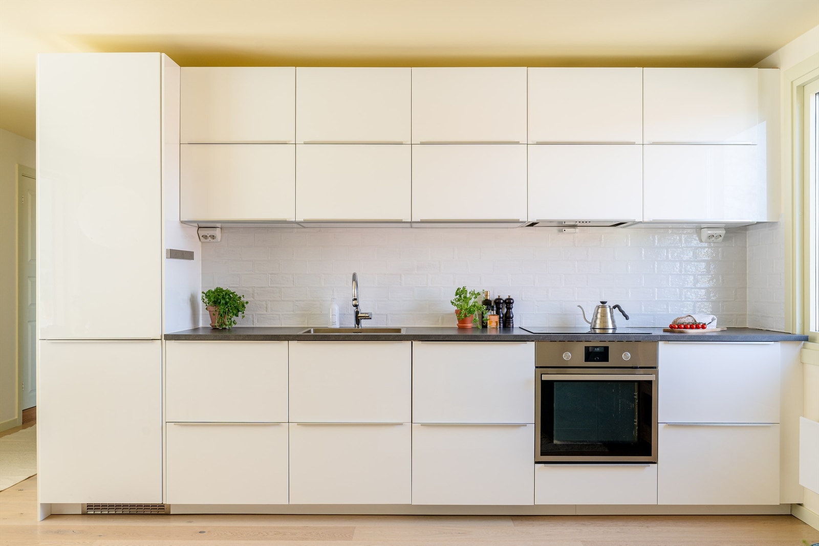 Kjøkkeninnredning fra Ikea er fra 2017 med slette fronter, laminat benkeplate og nedfelt vask av stål. Galleribilde