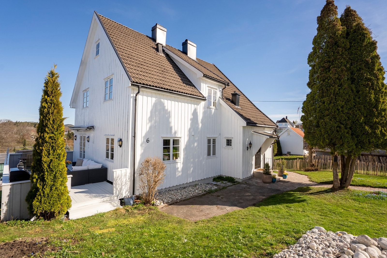 Åpning fra terrasse til hage og inngangsparti, der belegningsstein gir et rent og helhetlig uttrykk Galleribilde