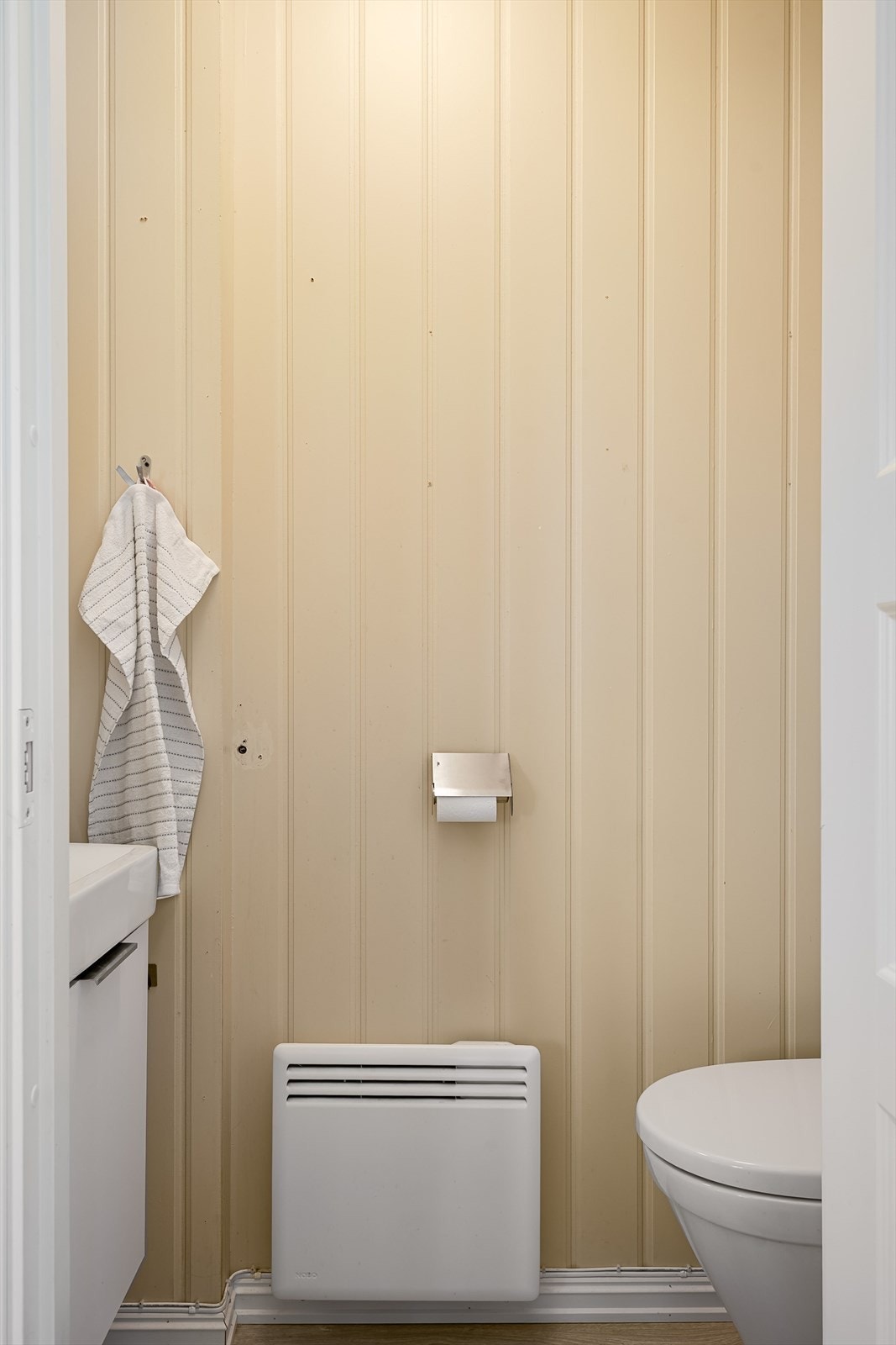 Fra gangen er det adkomst til toalettrommet i 1. etasje. Toalettrom med laminatgulv, malte plater på veggene og panel i himling. Galleribilde