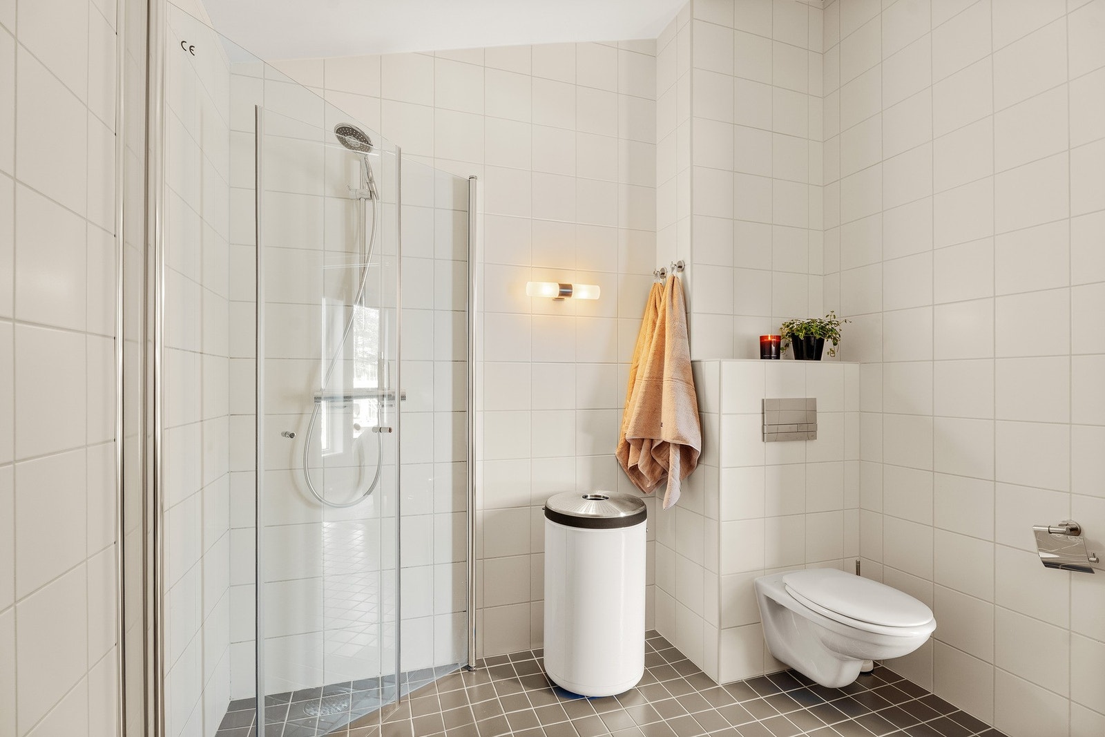 Badet utstyrt med dobbel servant med innredning, veggmontert toalett og dusjhjørne. Det er også plass til badekar i rommet. Galleribilde