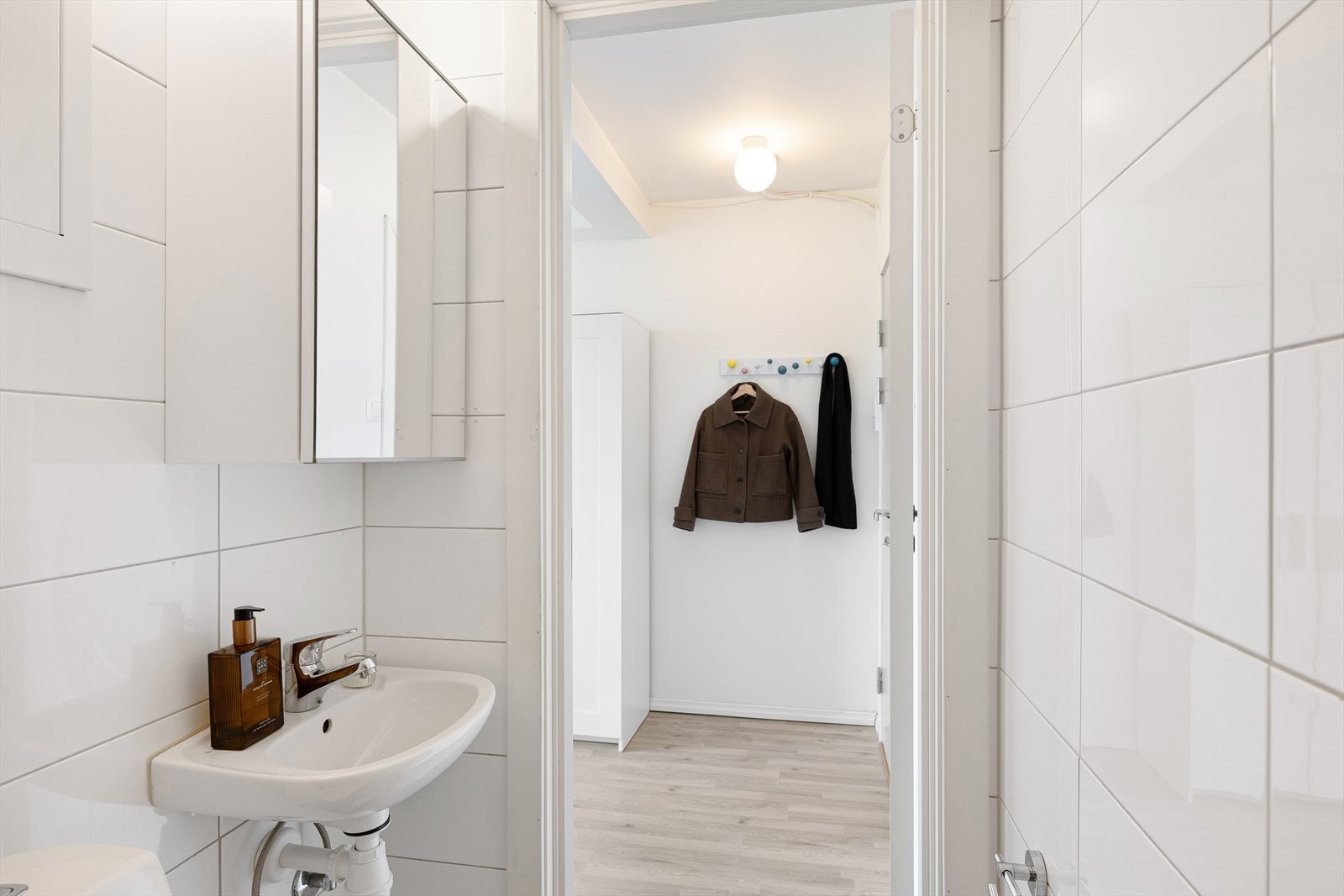 Badet er innredet med veggmontert WC, dusjplass med inn-utadslående dusjvegger og servant med ettgreps blandebatteri i innredning. Galleribilde