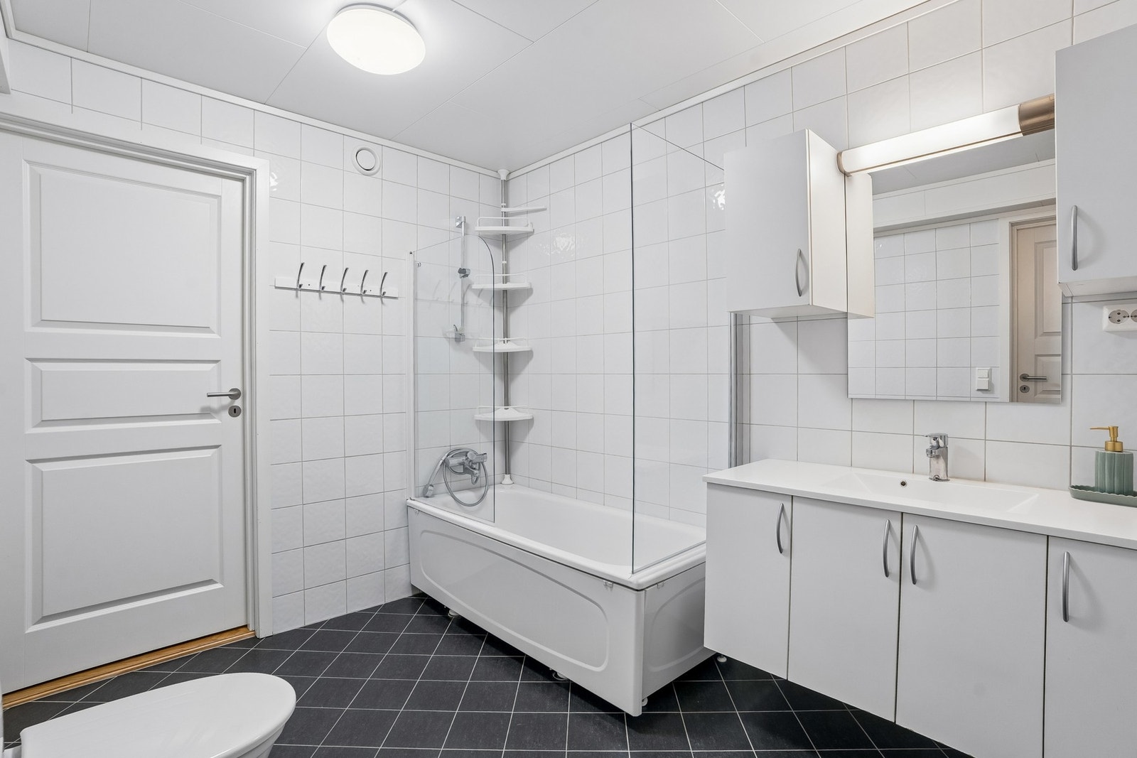 Badet er utstyrt med badekar, wc og baderomsinnreiing Galleribilde