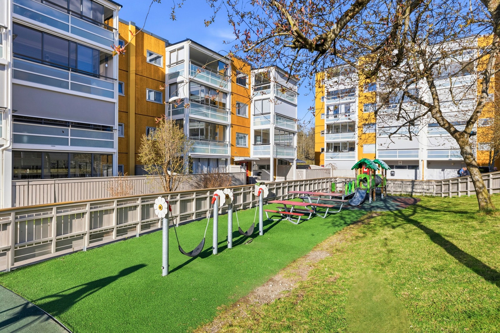 Området rundt boligen er fylt med grønt areal, lekeplasser og hyggelige omgivelser Galleribilde