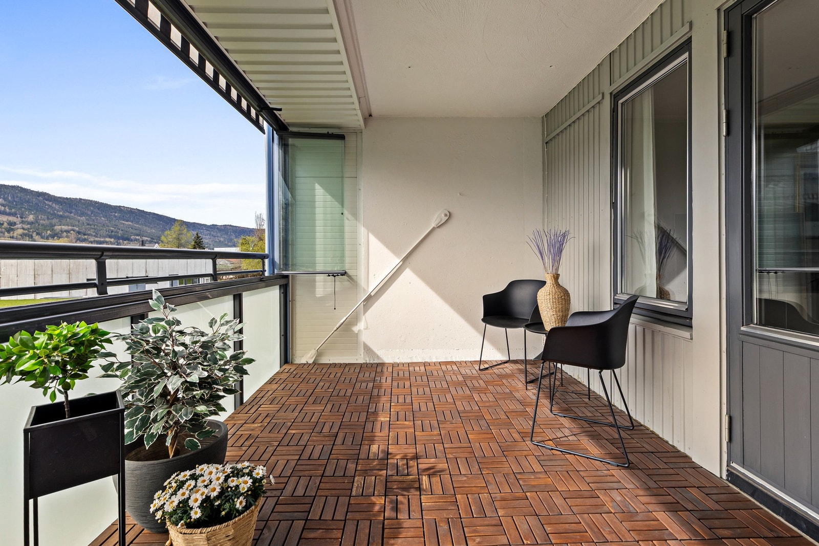 Balkongen har rekkverk av metall og skyvbare glassfelt Galleribilde