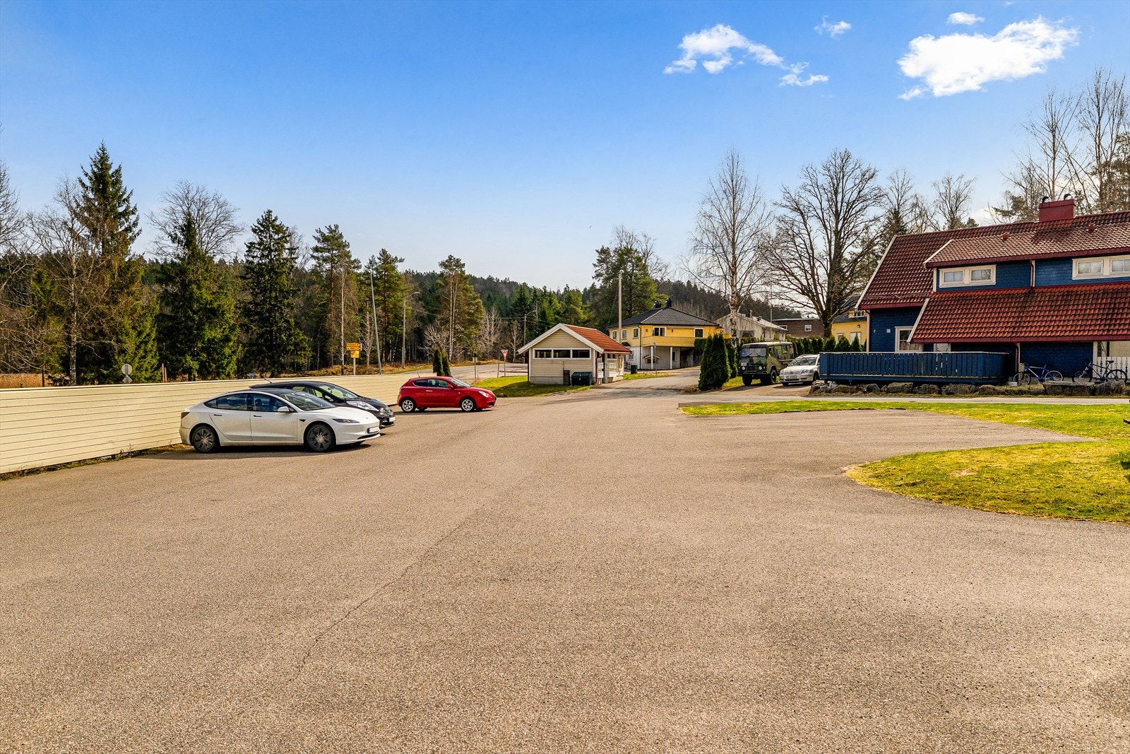 Asfaltert gårdsplass med biloppstillingsplass foran boligen. Galleribilde