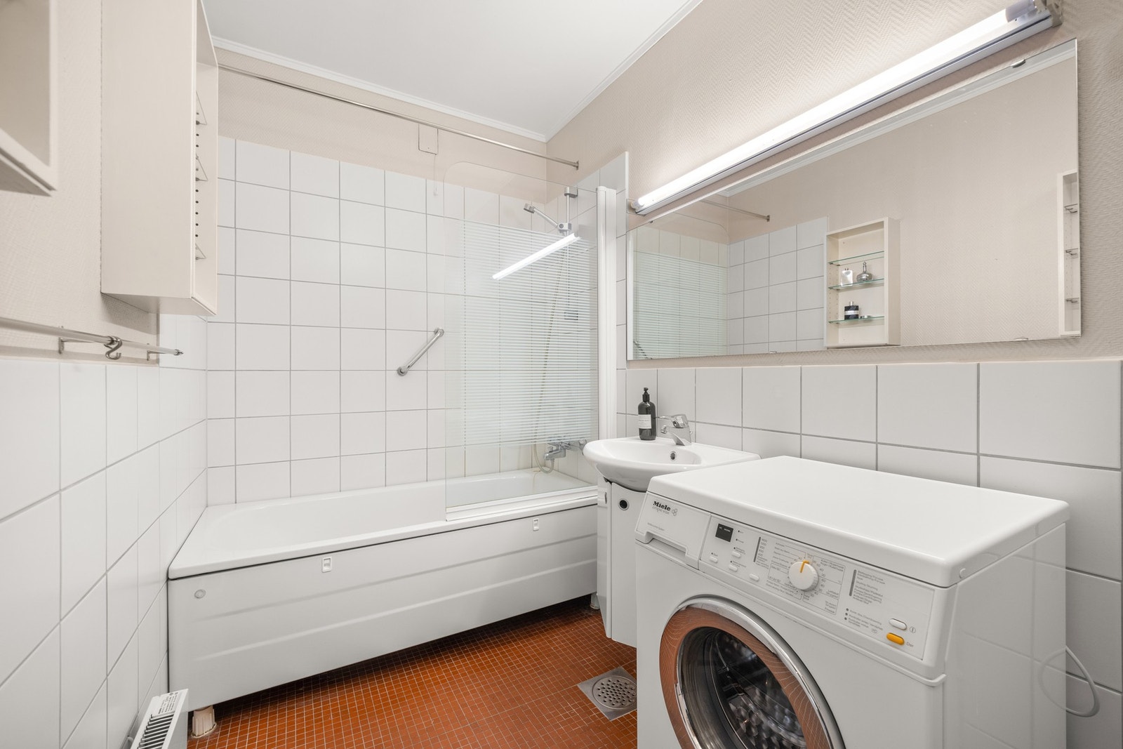 Stort, praktisk baderom med opplegg for vaskemaskin og tørketrommel. Galleribilde