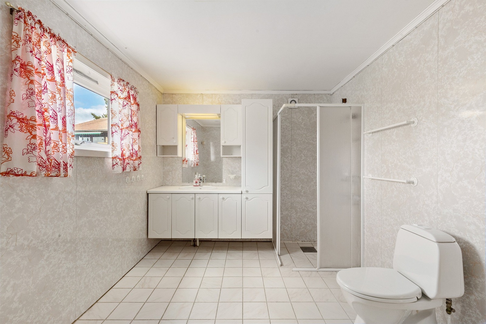 Baderom med våtromsplater, flislagt gulv og gulvvarme. Badet er utstyrt med opplegg for vaskemaskin, dusjhjørne, wc, servant og servantskap. Galleribilde