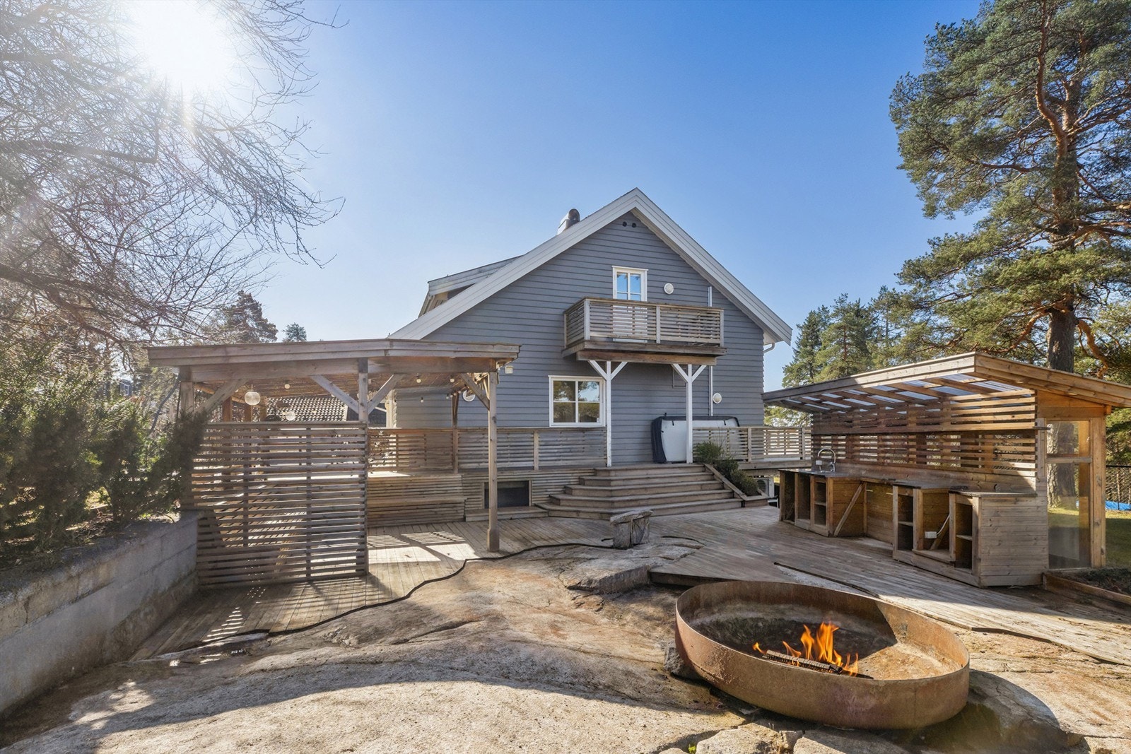 På nordsiden av boligen finner du et flott uteområde som er pent opparbeidet med pergola, fullt utstyrt kjøkken samt en hyggelig bålplass. Galleribilde