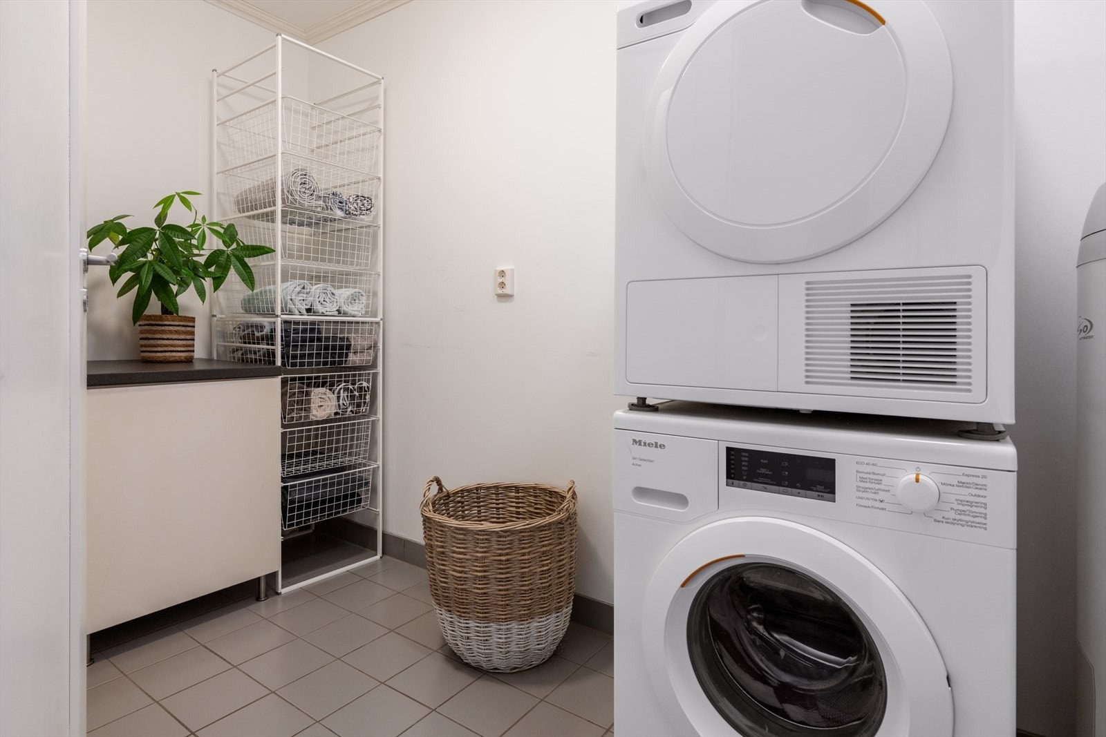 I underetasjen finner man et praktisk og pent vaskerom med flislagt gulv og malte vegger. Rommet er funksjonelt innredet med benkeplate, underskap, vaskekum og opplegg for vaskemaskin og tørketrommel, samt varmekabler i gulv. Galleribilde