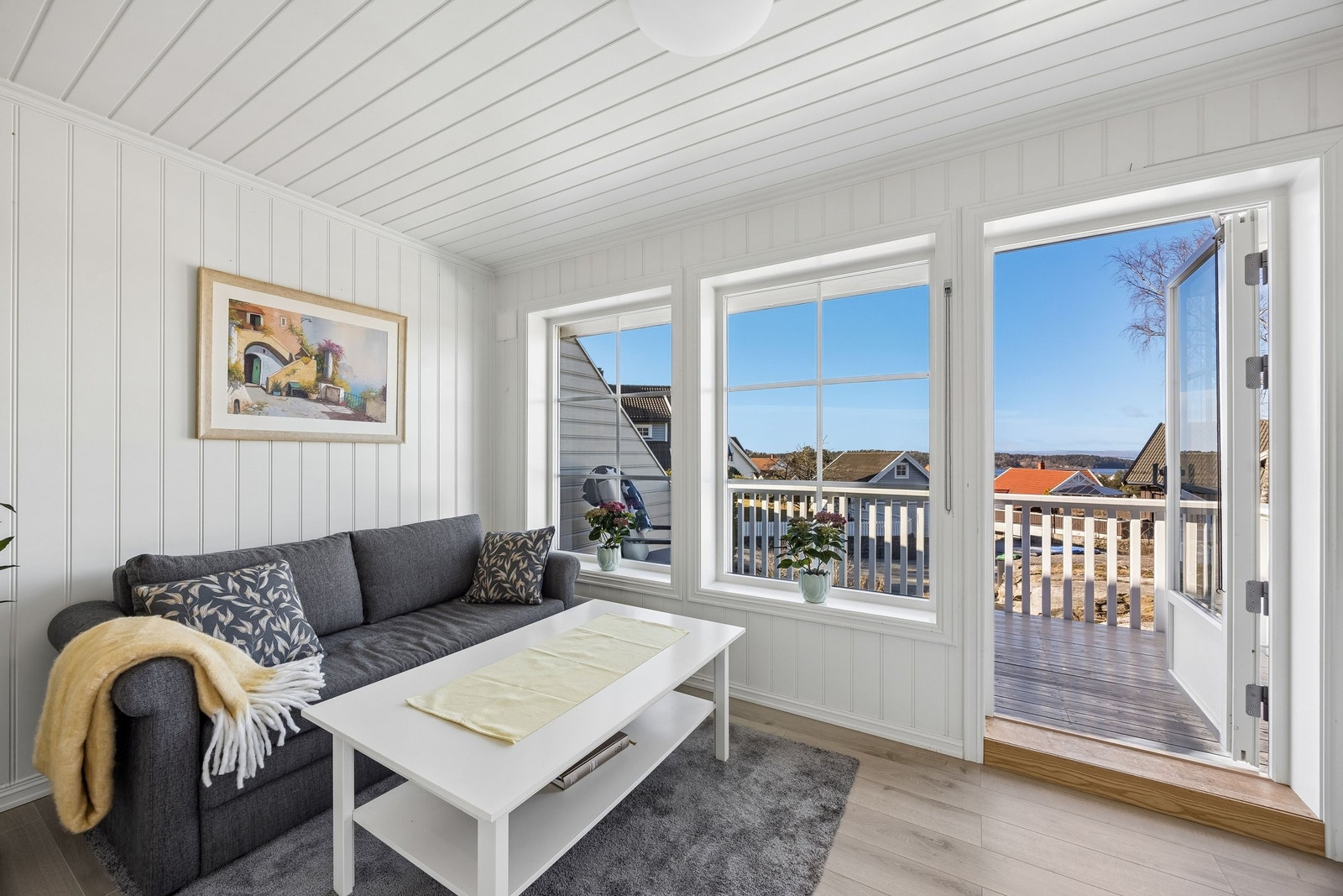 Lyst og hyggelig oppholdsrom i 2. etasje med store vinduer og utgang til veranda. Galleribilde