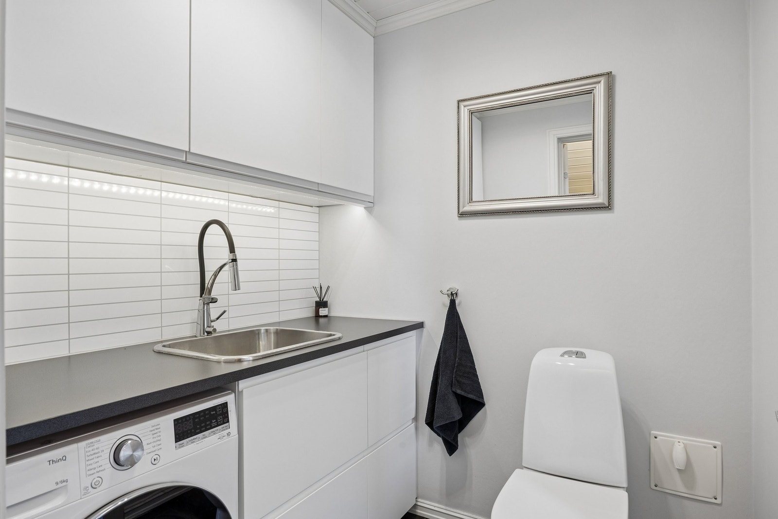 Praktisk vaskerom med wc, god benkeplass og opplegg for vaskemaskin. Galleribilde