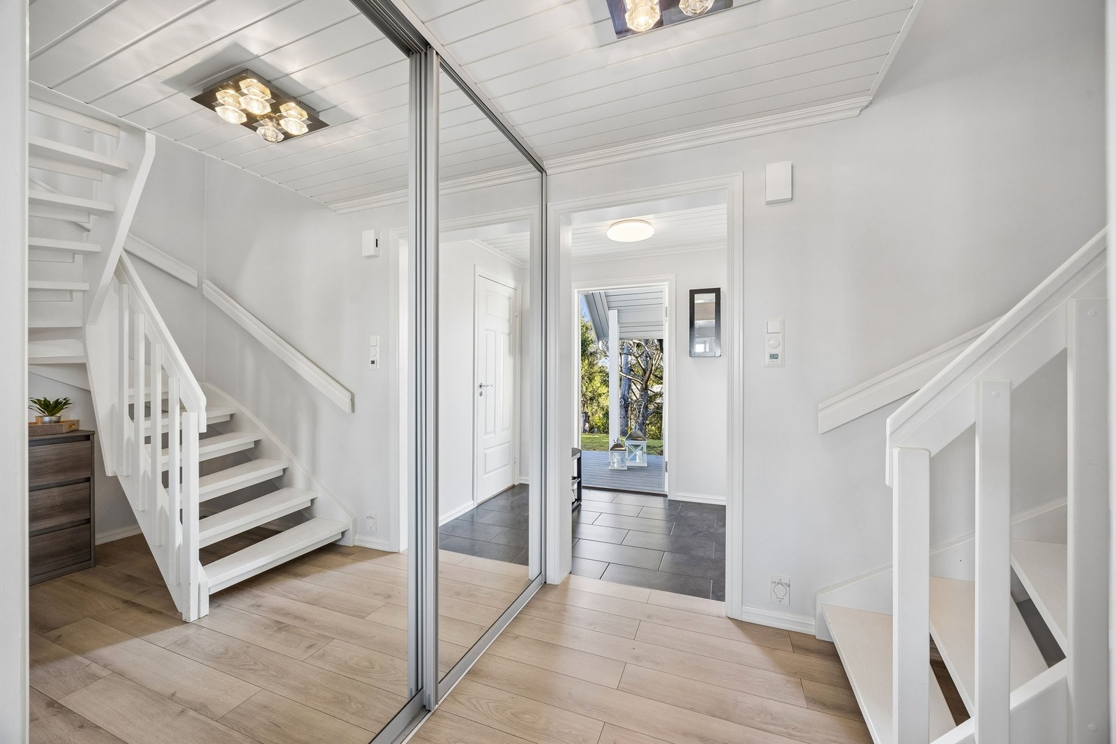 Lys og innbydende hall med praktisk trappeløsning og skyvedørsgarderobe. Galleribilde