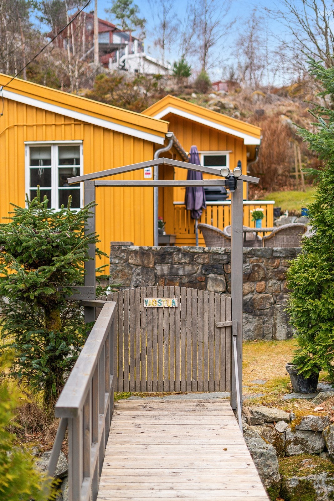 Liten bro over bekken med dør inn til tomten Galleribilde
