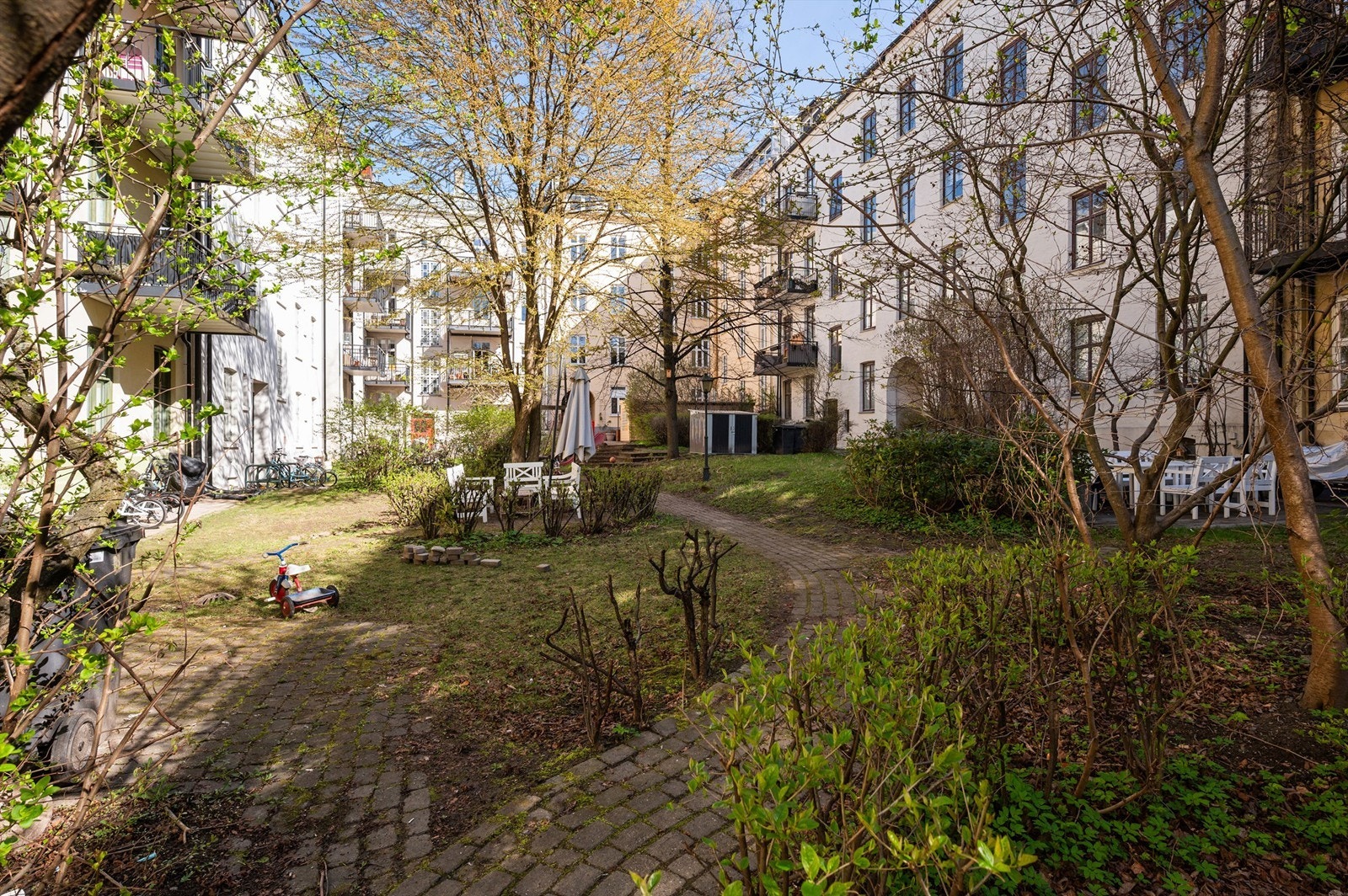 Den sjarmerende bakgården er en frodig oase for beboerne, med sittegrupper og god plass for rekreasjon. Galleribilde