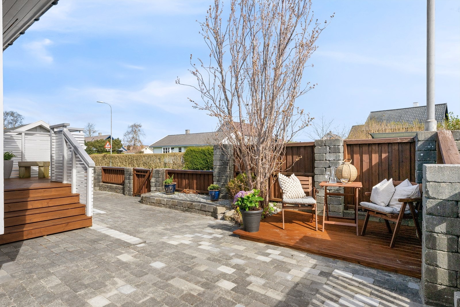 Tomten er pent opparbeidet med belegningsstein, terrasser og beplantning. Galleribilde