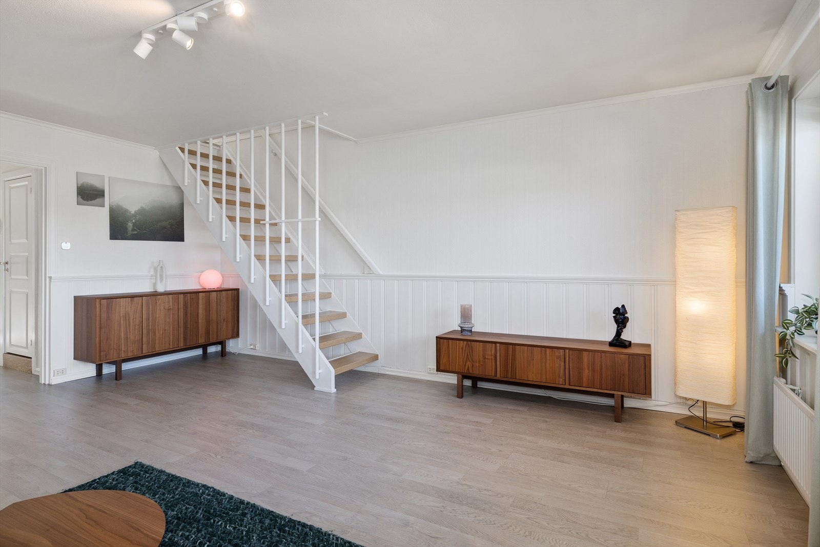 En lakkert tretrapp leder opp til leilighetens andre plan med soverommene. Galleribilde