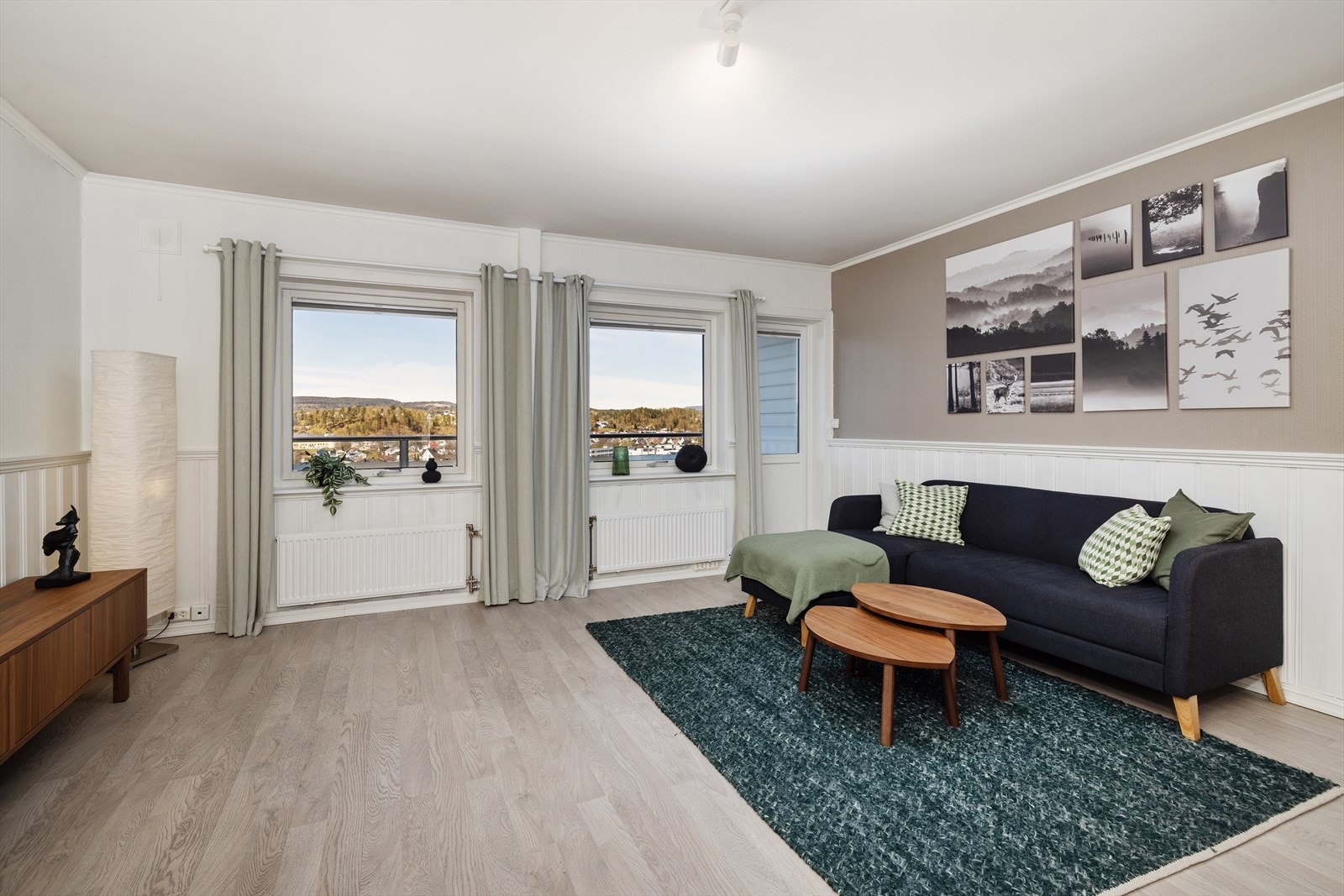 Gjennomgående laminatgulv og lysmalte flater gir et helhetlig og tidsriktig inntrykk. Galleribilde