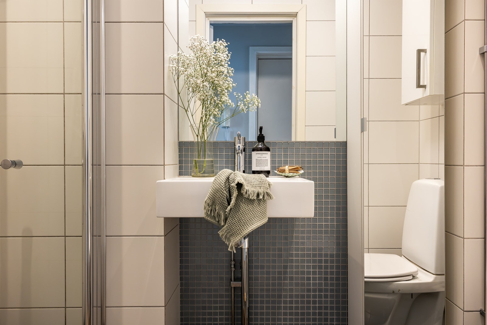 Badet er holdt i lyse, tidløse farger og er utstyrt med servant, speilskap, gulvstående toalett og dusjløsning. Galleribilde