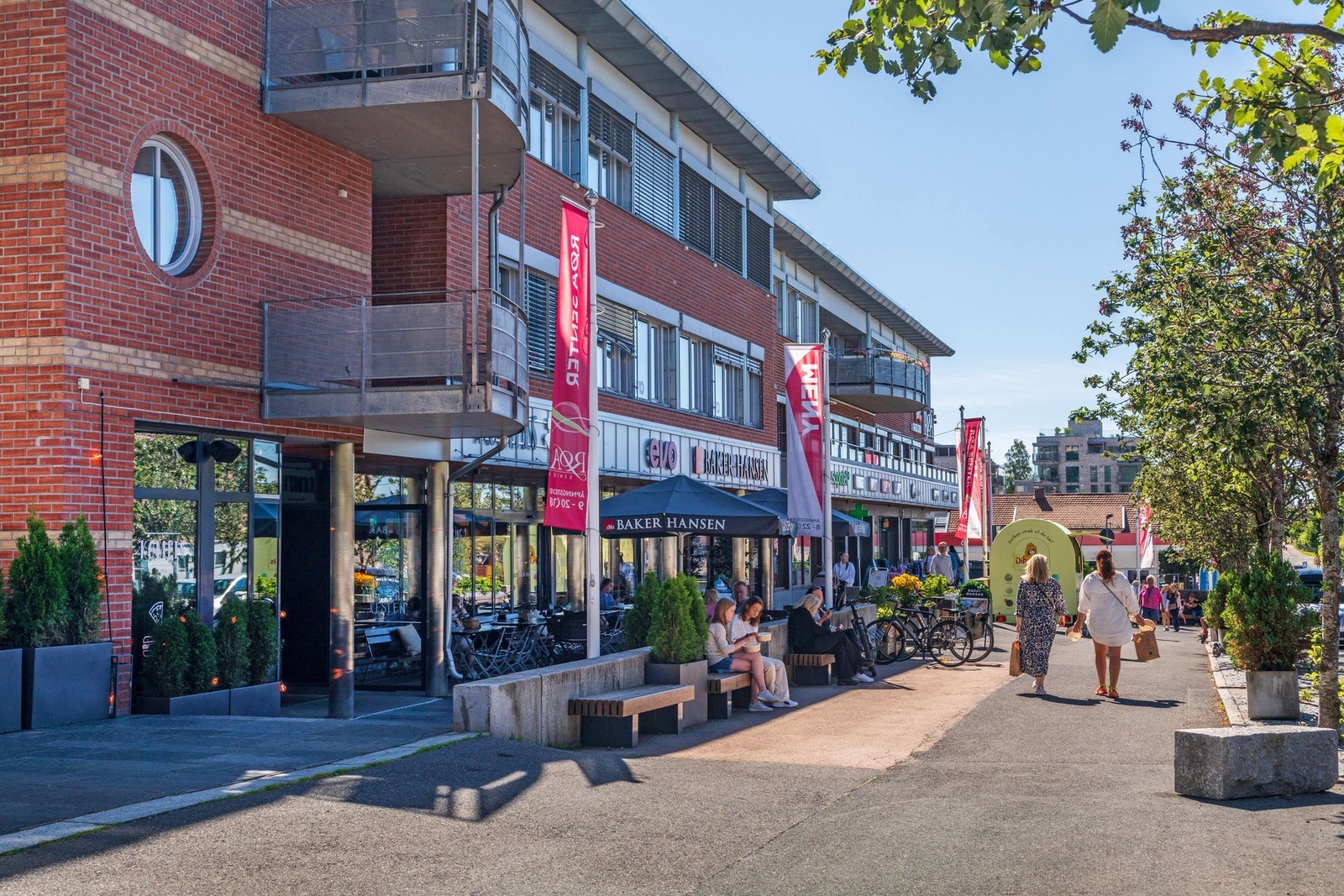 Koselig gate med butikker, serveringssteder og uteservering. Galleribilde