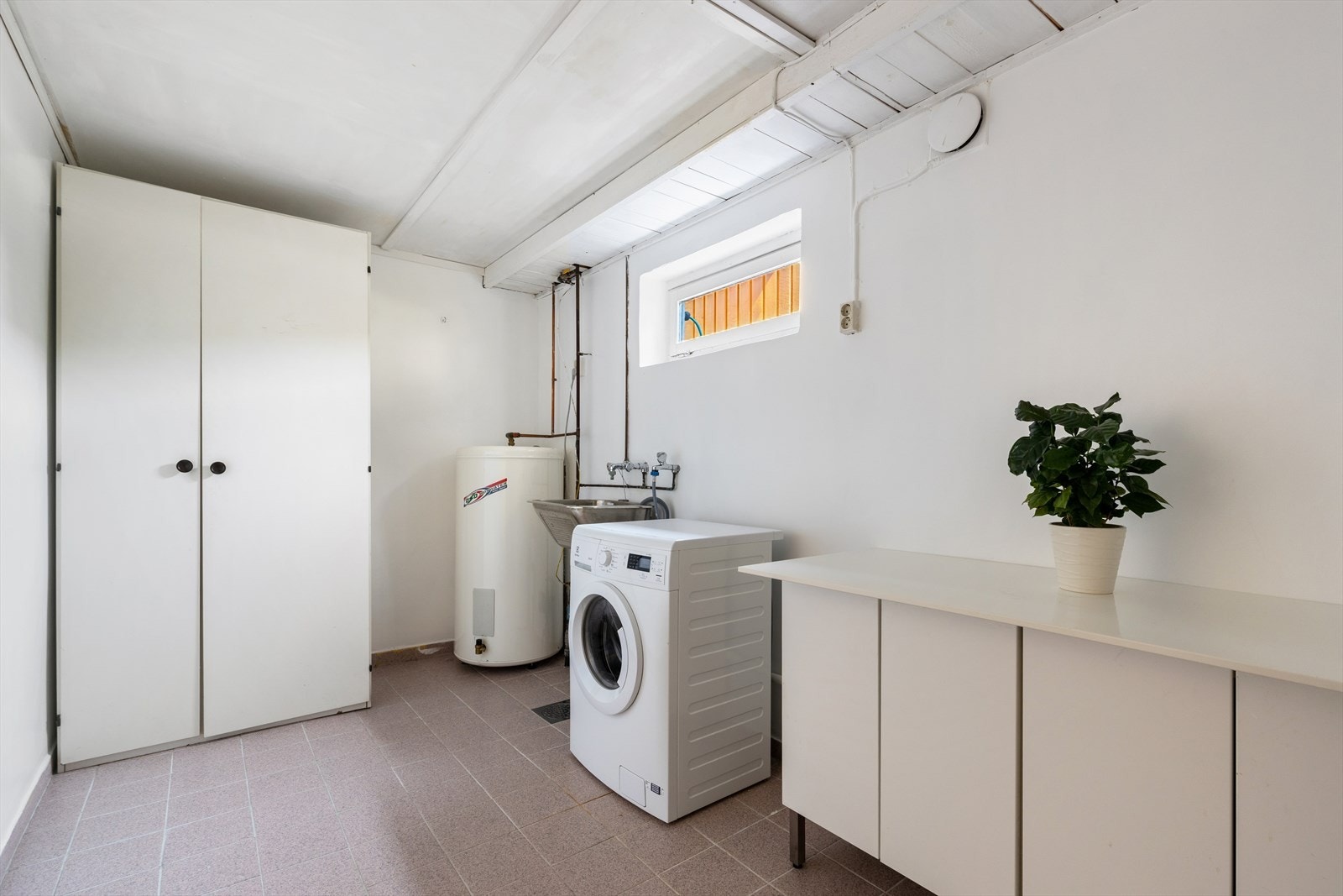 Kombinert bad og vaskerom som er en ombygning av tidligere vaskerom. Rommet er utstyrt med innredning og laminat benkeplate med sevant, høyskap og opplegge for vaskemaskin. Galleribilde
