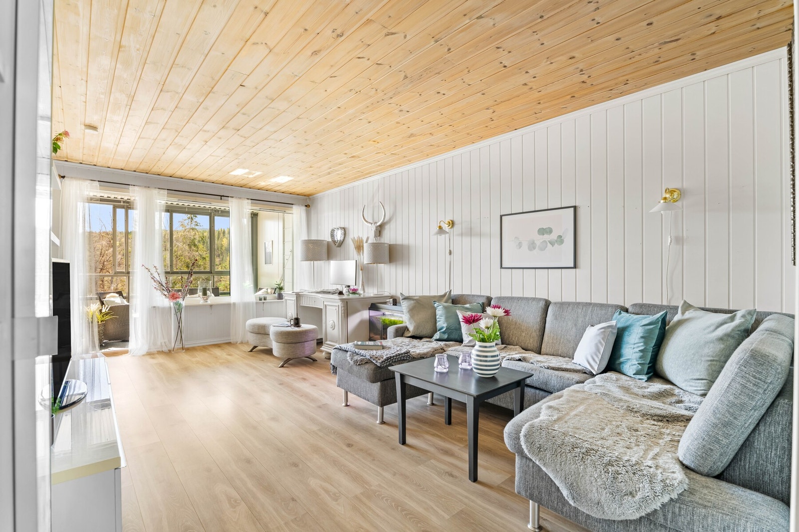 Rommet har godt med naturlig lysinnslipp gjennom store vinduer, og den delvis lukkede løsningen gir en skjermet og hyggelig stueatmosfære. Galleribilde