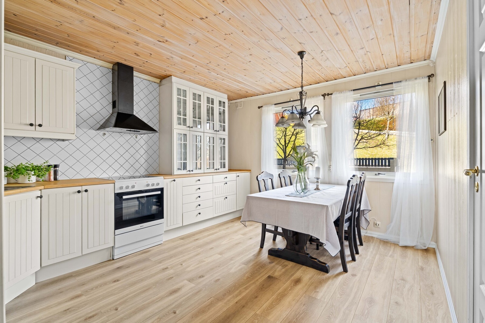 Kjøkkenet har plass til spisebord med tilhørende sitteplasser for familien, og hvitevarer inkluderer komfyr med keramisk platetopp, oppvaskmaskin samt kjøleskap med fryser. Galleribilde