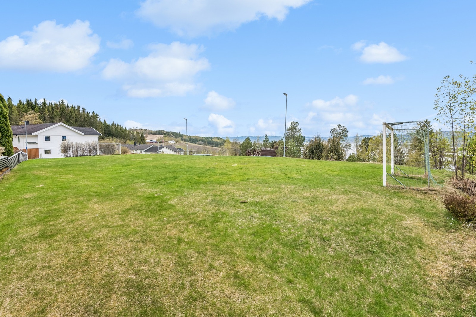 Felles uteområde i boligfeltet med fotballbane, trampoliner, lekestativ og en platting med sittemøbler. Et godt utgangspunkt for et trivelig naboskap. Galleribilde