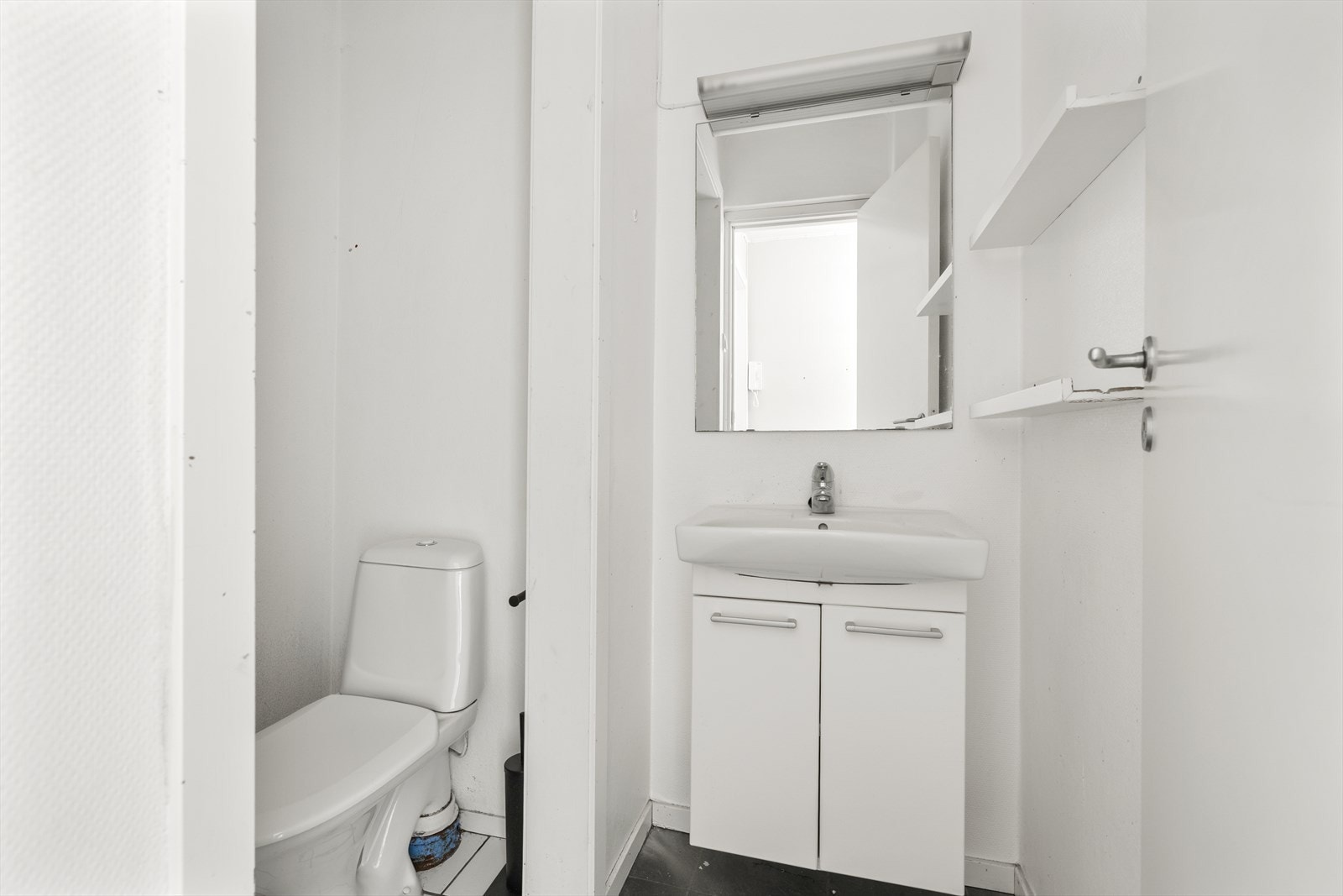 WC-rommet er utstyrt med servantskap, toalett, speil, belysning og hyller. Galleribilde