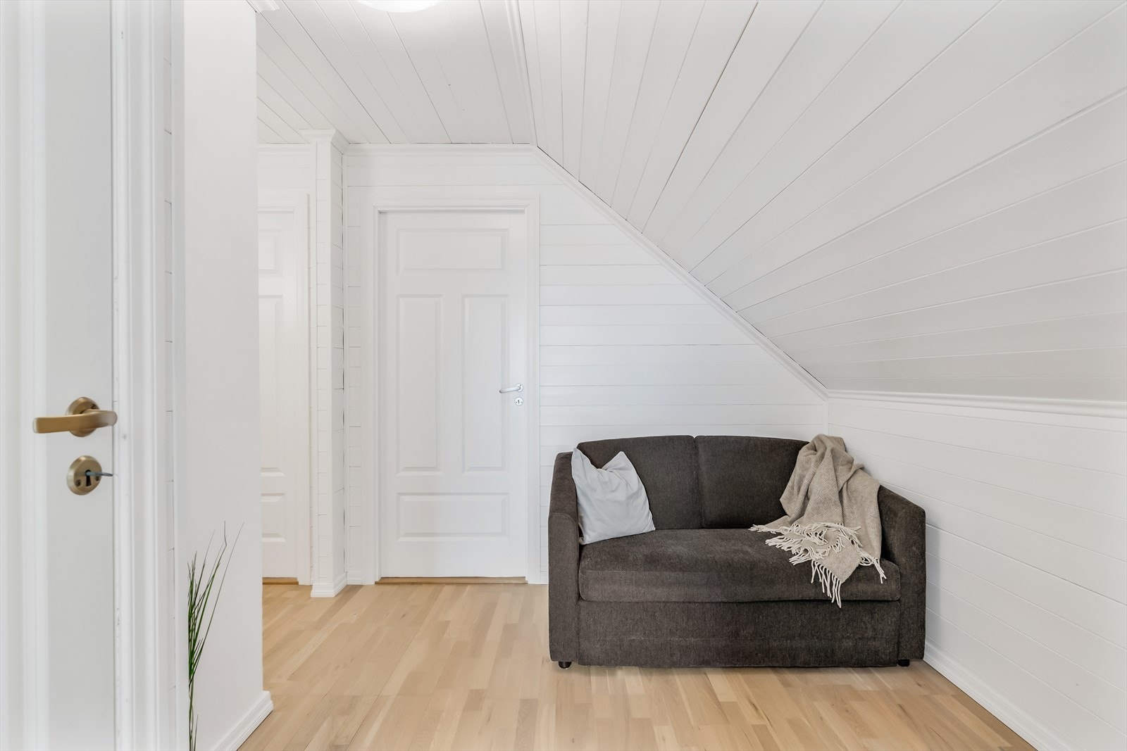 Gangen i loftsetasjen har malte panelvegger og -tak, og fordeler tilgangen til etasjens rom. Galleribilde