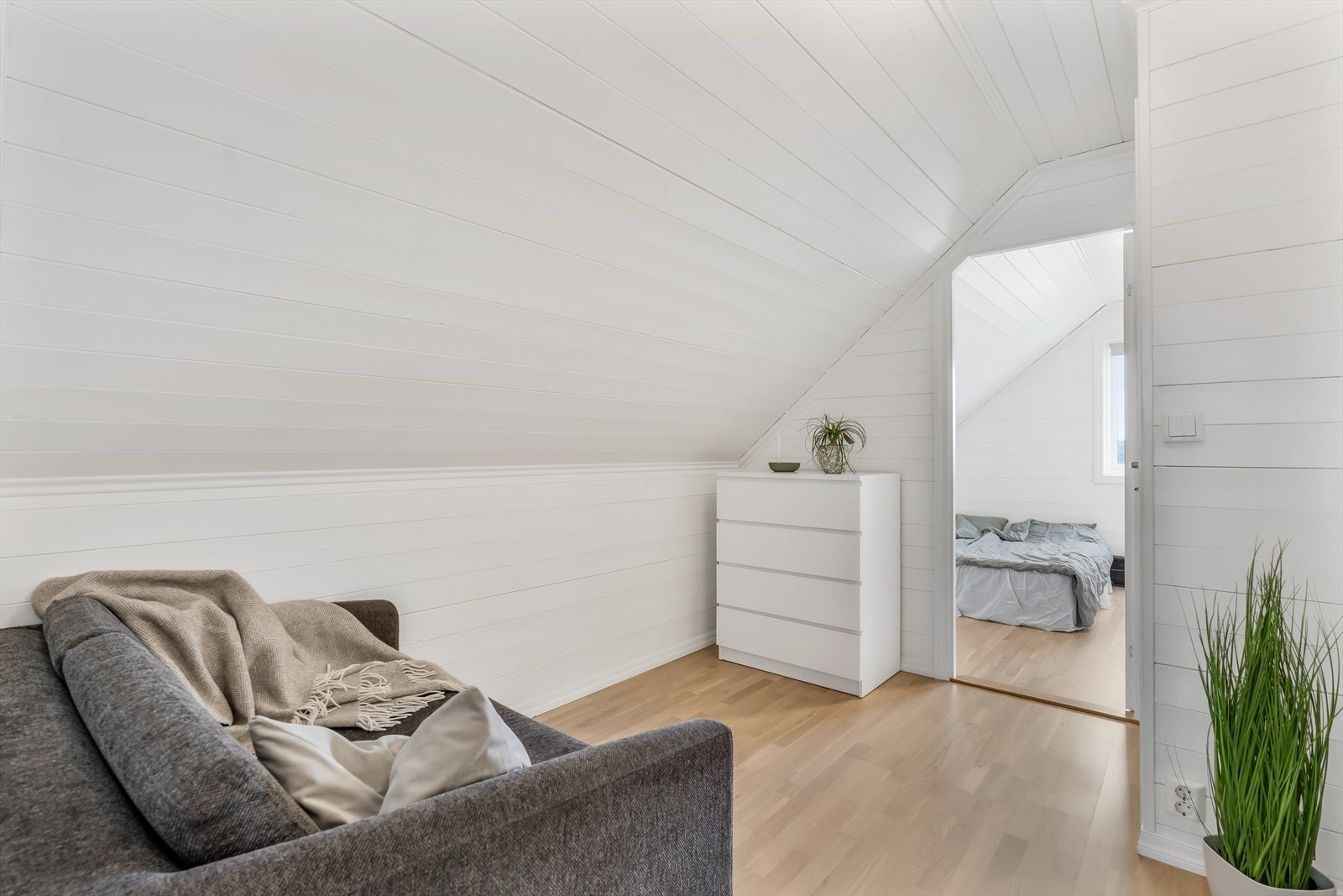 En lys og åpen gang med plass til en liten sittegruppe eller oppbevaringsmøbler. Galleribilde
