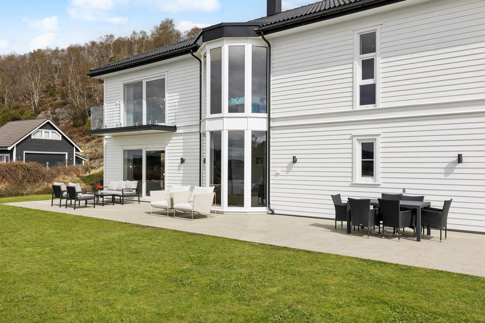 Den store, støpte terrassen gir rikelig med plass for flere sittegrupper og sosiale sammenkomster. Galleribilde