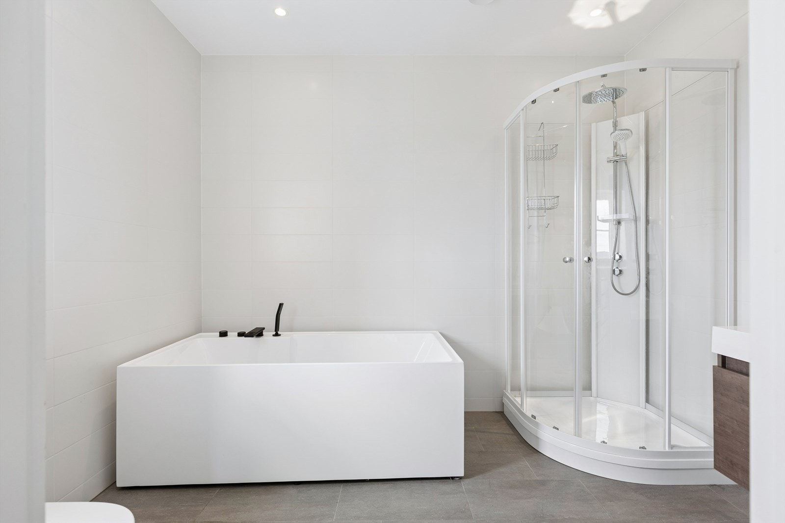 Videre leder garderoben inn til et moderne bad, noe som gir en privat og funksjonell mastersuite med god komfort i hverdagen. Galleribilde