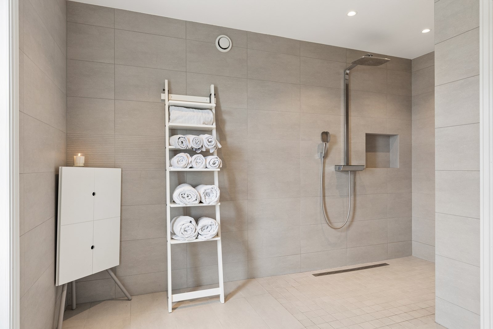 Den romslige dusjsonen har slukrenne og regnfallsdusj. Badet har elektrisk gulvvarme for økt komfort. Galleribilde