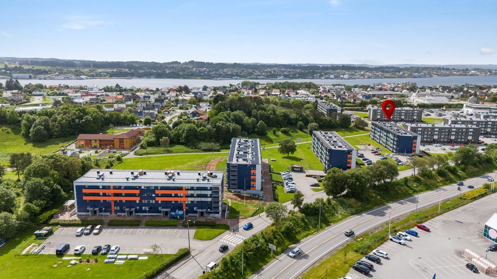 Pent opparbeidet fellestomt med asfalterte parkeringsplasser og stort grøntareal Galleribilde