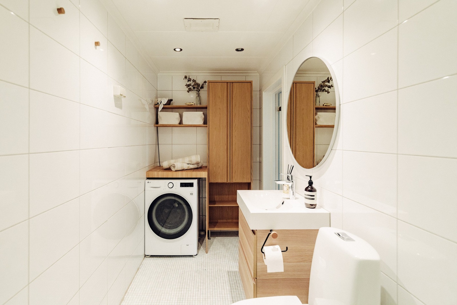 Leiligheten har et innbydende bad med lyse fliser på gulv og vegger. Badet er utstyrt med servantskap med nedfelt servant, speil, toalett og badekar med dusjløsning og glassvegg. Galleribilde
