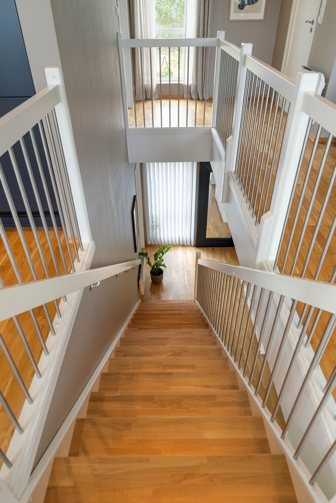 Stilren eiketrapp med stålgjerde, som gir et moderne preg og reduserer vedlikeholdsbehovet. Galleribilde