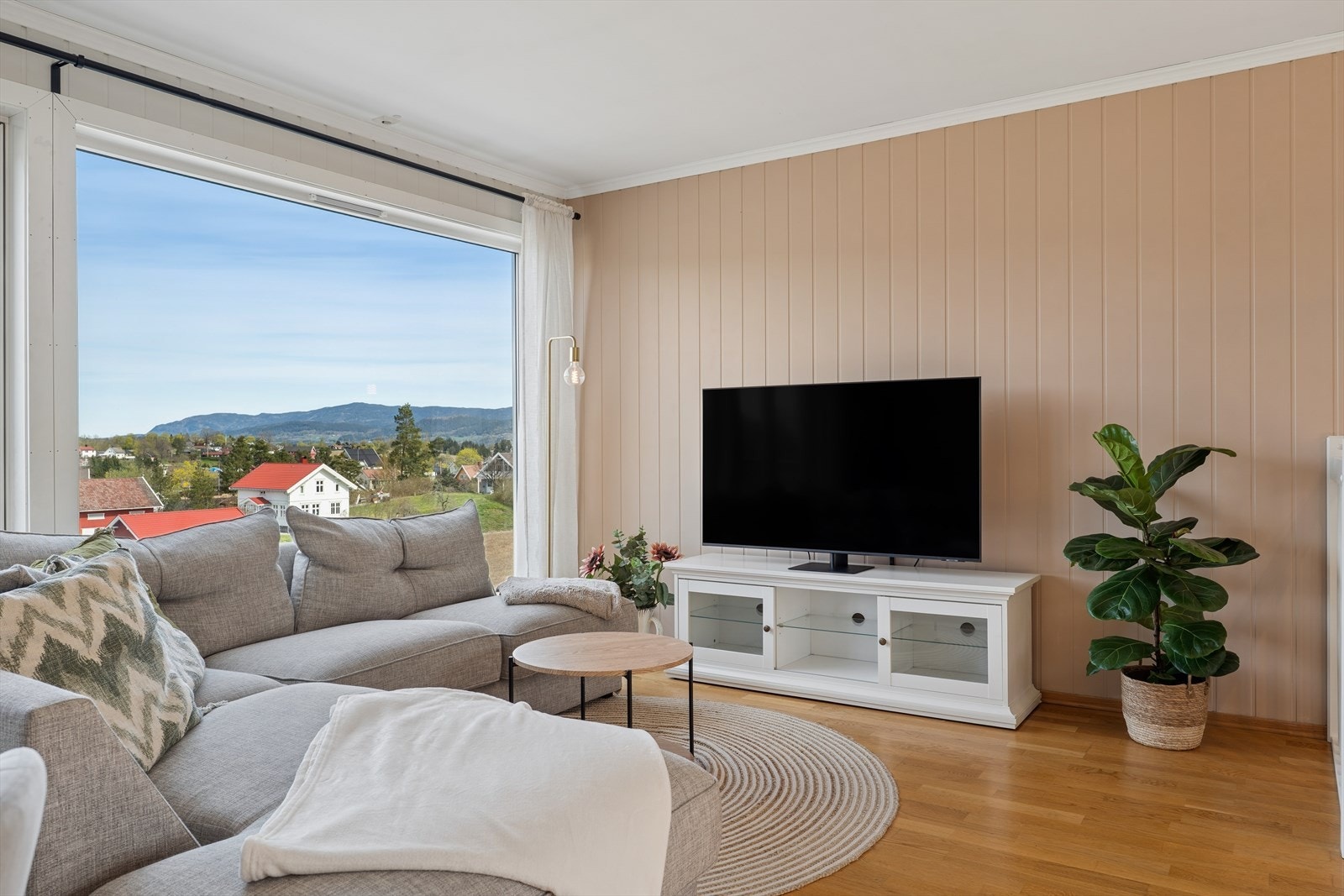 Sofagruppen er naturlig plassert ved vinduene, noe som gir rikelig med dagslys og en behagelig atmosfære. Galleribilde