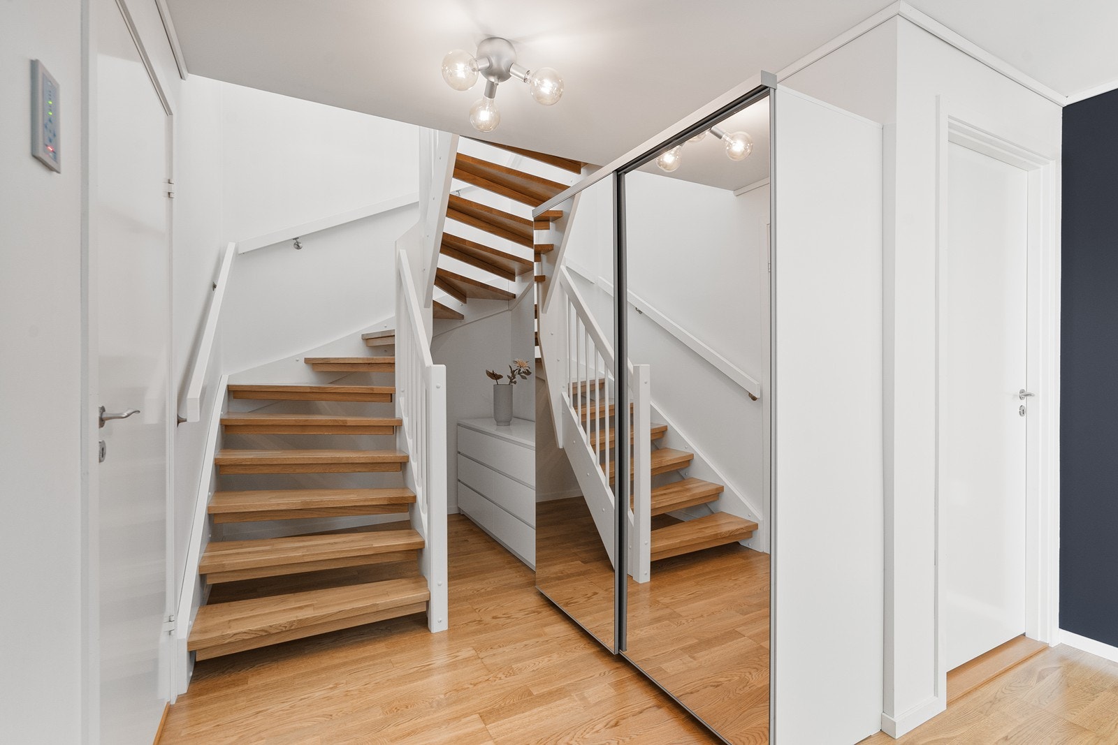 Entré/gang er romslig og innredet med skyvedørsgarderobe med speildører, som gir rikelig med plass til oppbevaring av yttertøy og sko. Fra entréen leder en trapp opp til hovedetasjen. Galleribilde