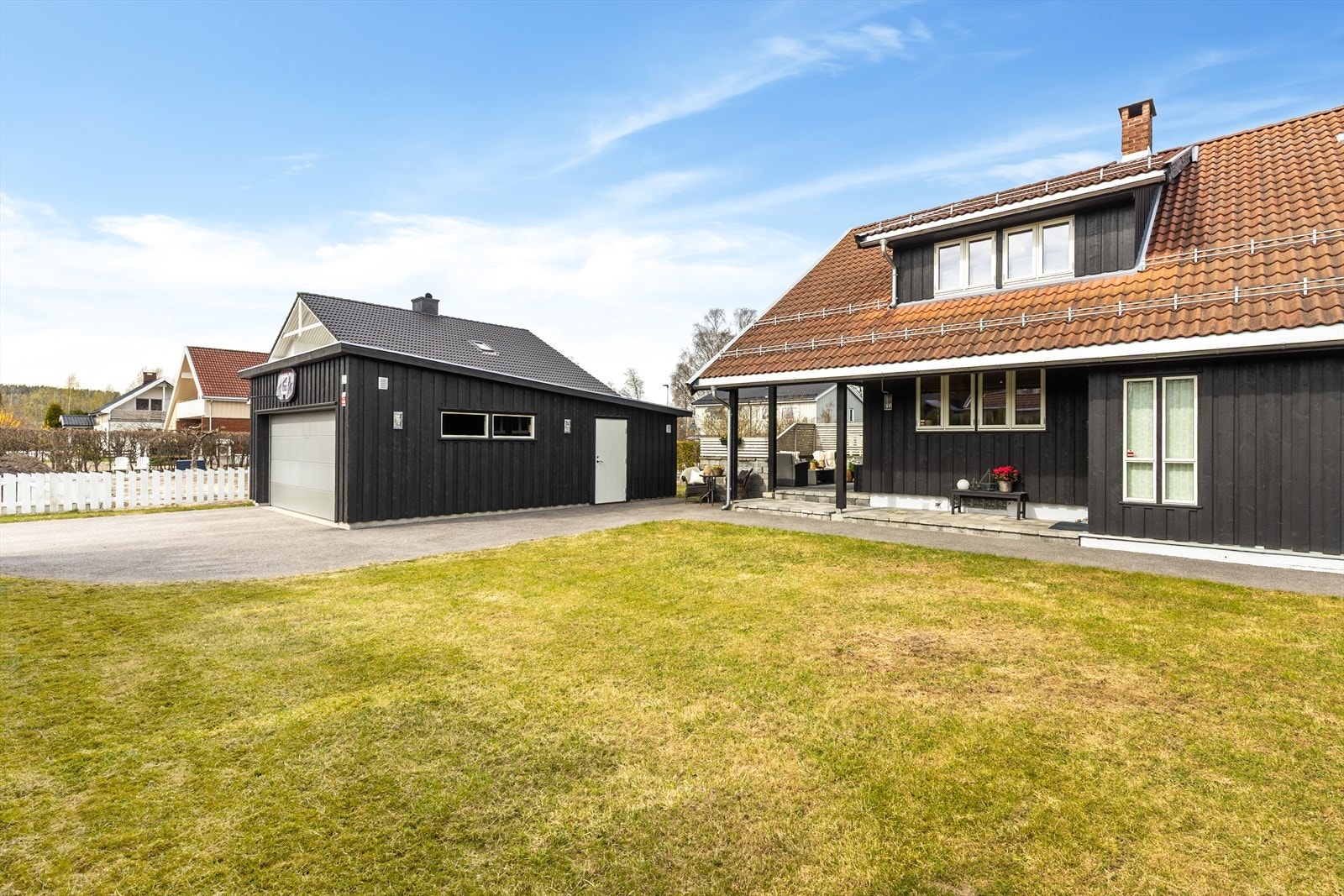 Asfaltert gårdsplass med god plass til parkering foran den doble garasjen. Galleribilde