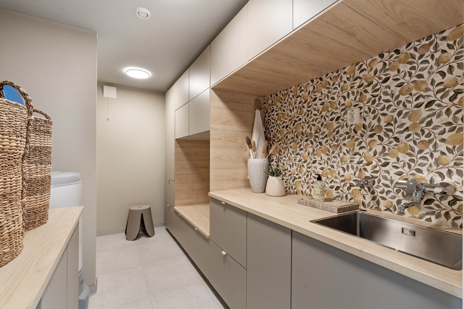 Grovkjøkken (vaskerom) med praktisk innredning fra IKEA og med smart forhøyet plassering av vaskemaskin/tørketrommel. Galleribilde