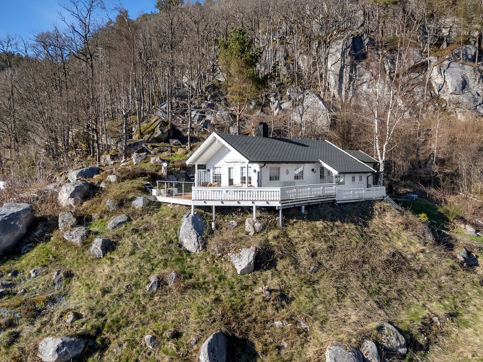 En klassisk fritidsbolig, høyt og fritt beliggende i skrånende terreng med flott utsikt over sjøen. Hytta er oppført i 1993 og fundamentert på pilarer. Galleribilde