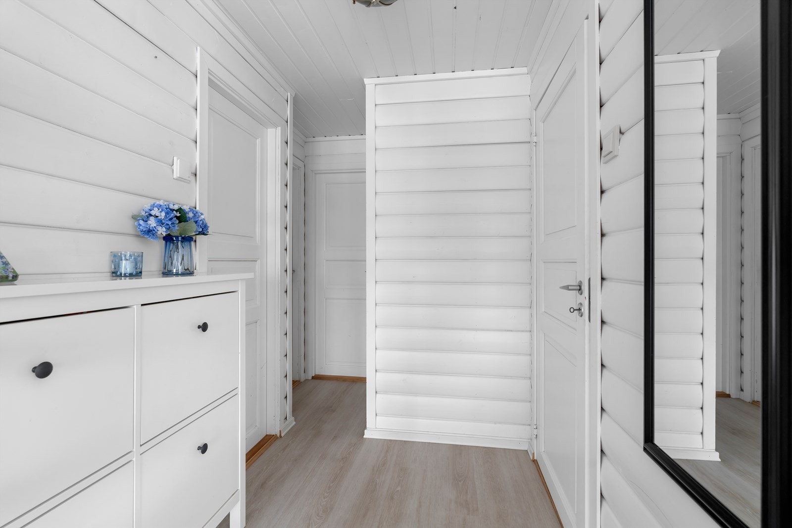 Gangen leder videre inn til hyttas oppholdsrom og soveromsavdeling. Overflatene består av laminat vinylplanke på gulv og trepanel på vegger og i tak. Galleribilde